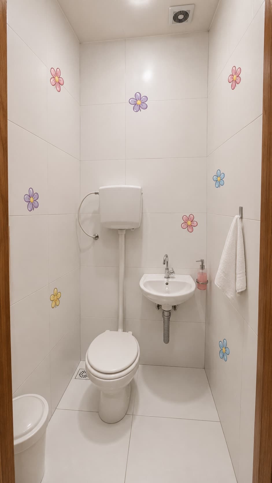 Banheiro infantil da Escola Avanço com decoração de flores, pia e vaso sanitário