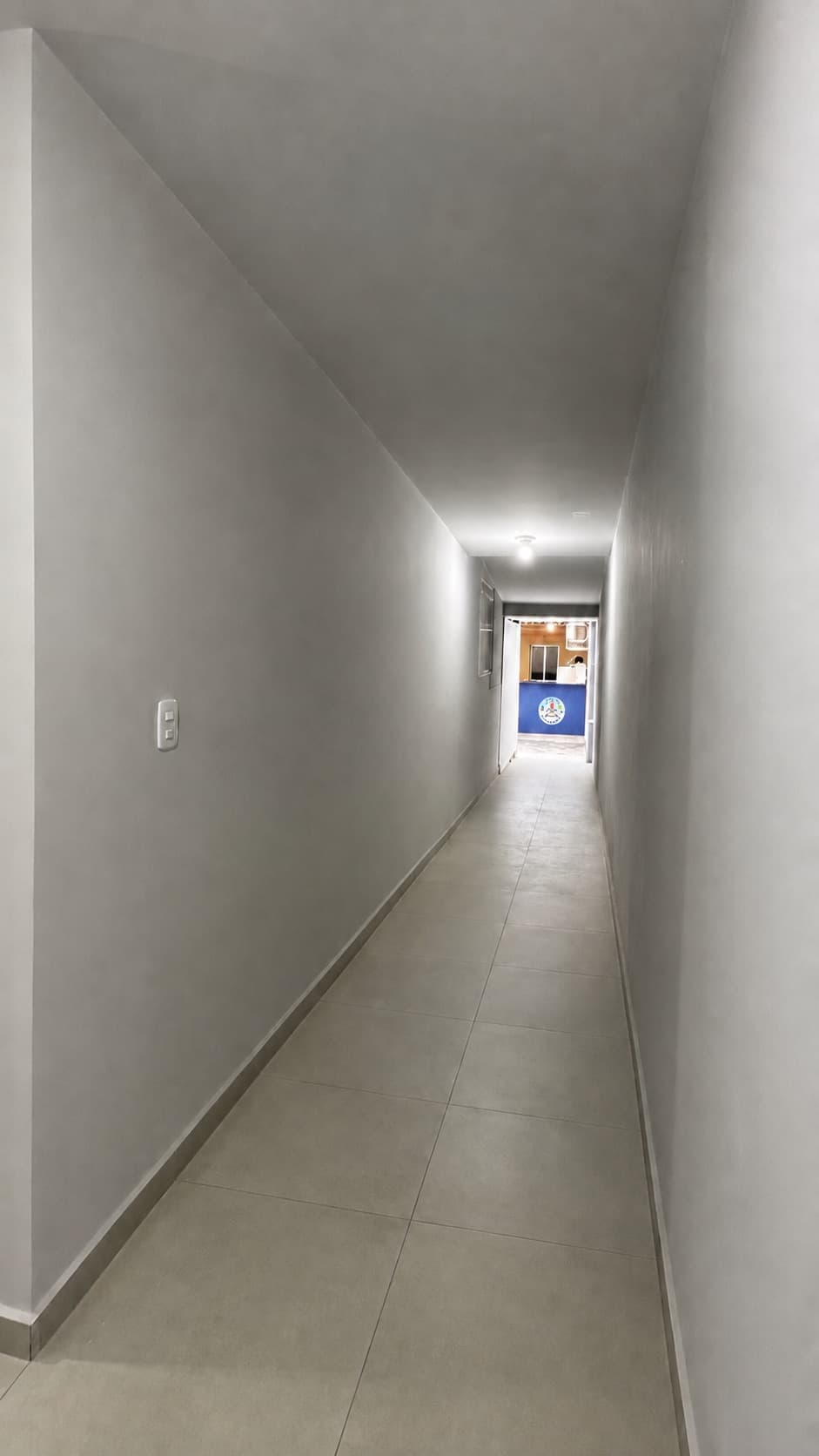 Corredor interno da Escola Avanço com piso claro, iluminação e portas das salas