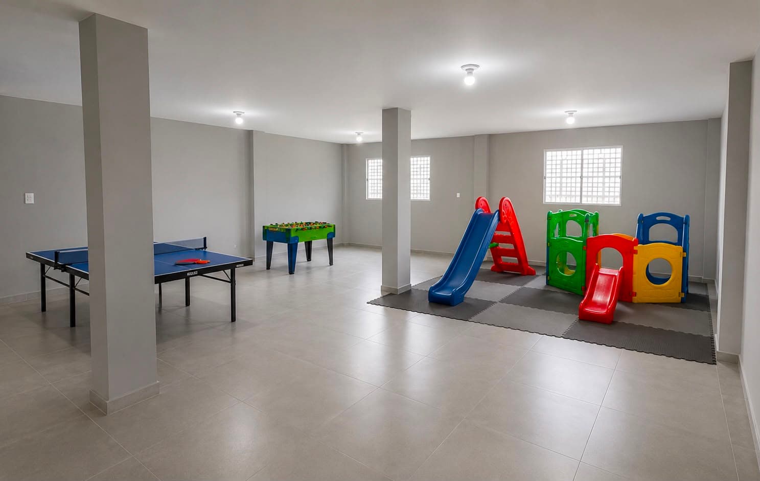 Espaço de recreação da Escola Avanço com brinquedos, escorregadores e mesa de jogos