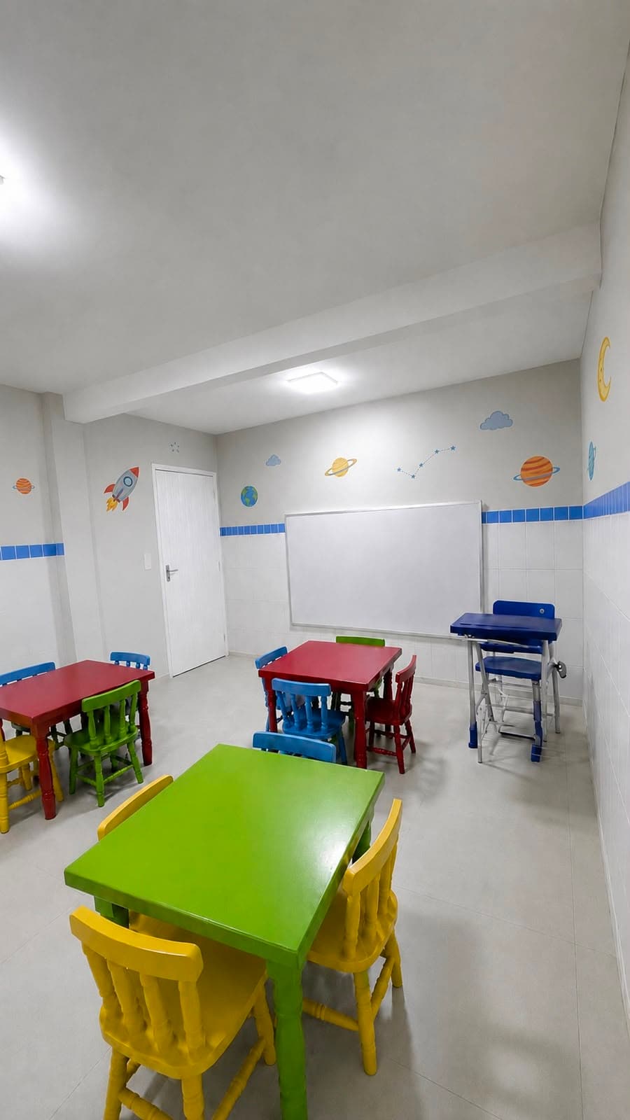 Sala da Educação Infantil da Escola Avanço com mesas e cadeiras coloridas